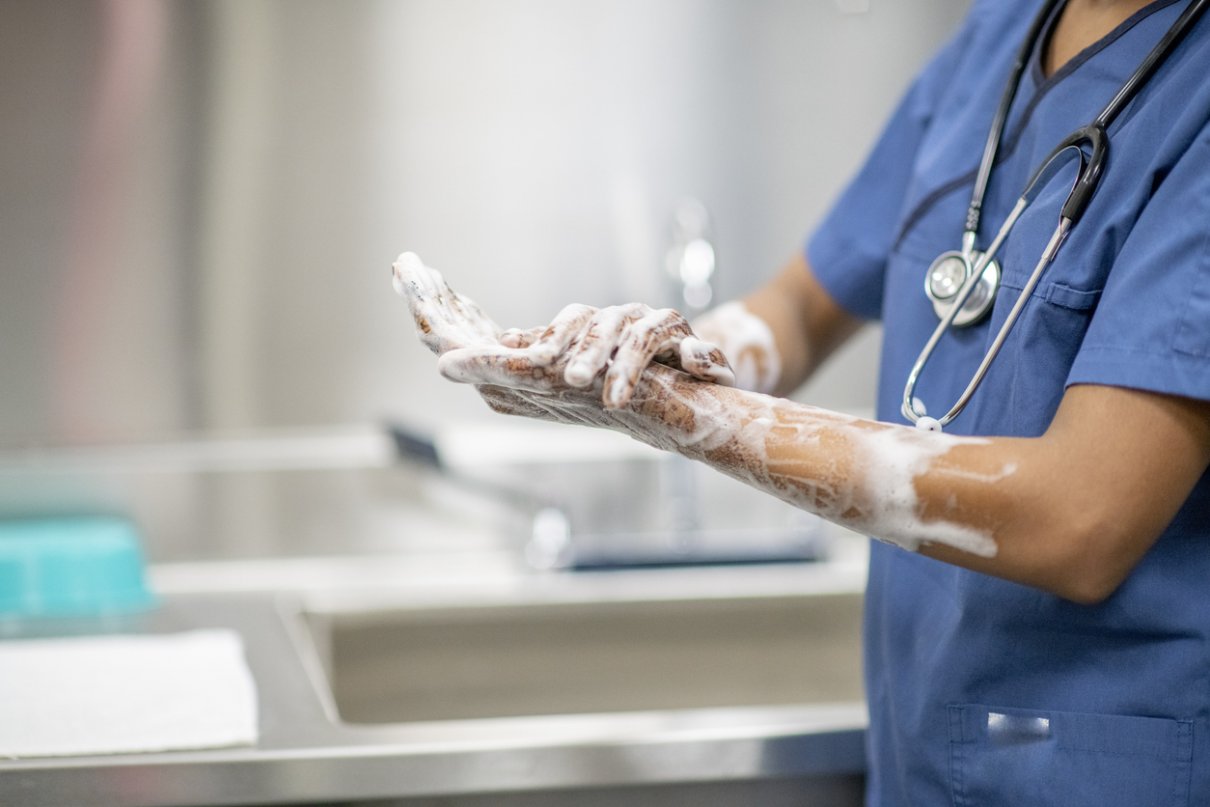 A medical staff member avoiding passing on hospital-acquired infection by washing hands.