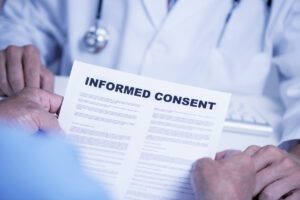 Male patient reviewing an informed consent contract with his doctor.