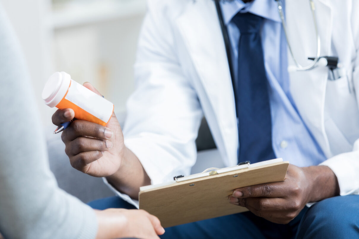 a doctor handing a patient post-operative medication to a patient.
